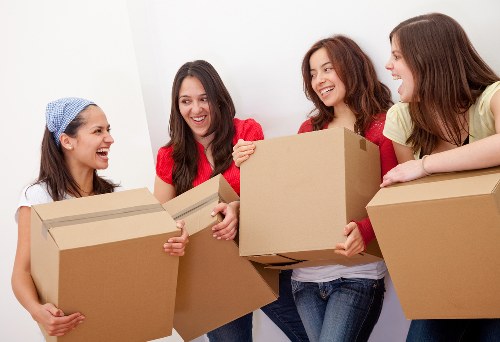 A removals team preparing household items for transport in Merton