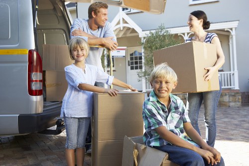 Piano movers transporting an instrument through a South West London property