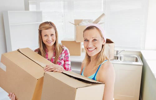 Mover wearing PPE while carrying household items